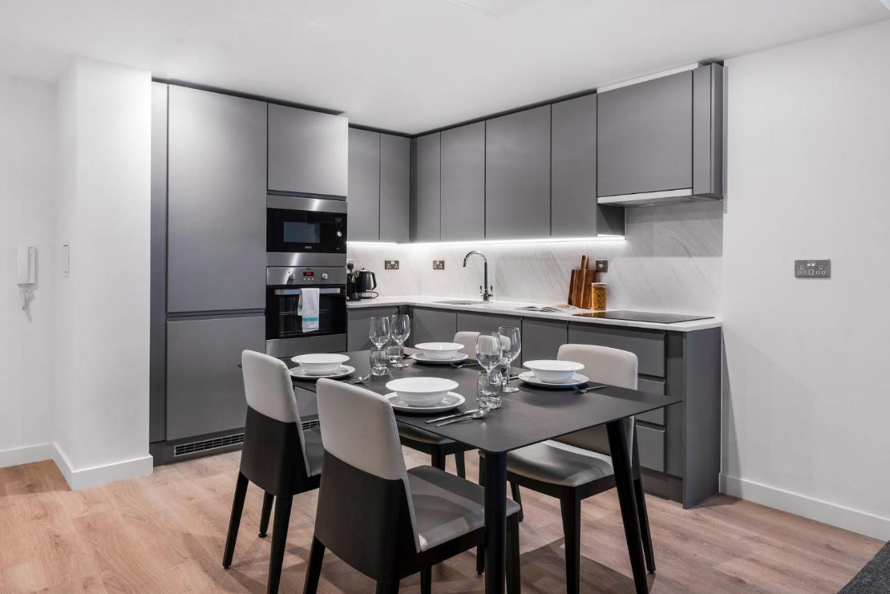 Citysuites 2 Aparthotel Manchester Exterior foto The photo shows a modern kitchen and dining area. The kitchen features sleek, gray cabinetry and a countertop that complements the overall aesthetic. There are built-in appliances, including an oven and refrigerator, arranged neatly. Next to the kitc