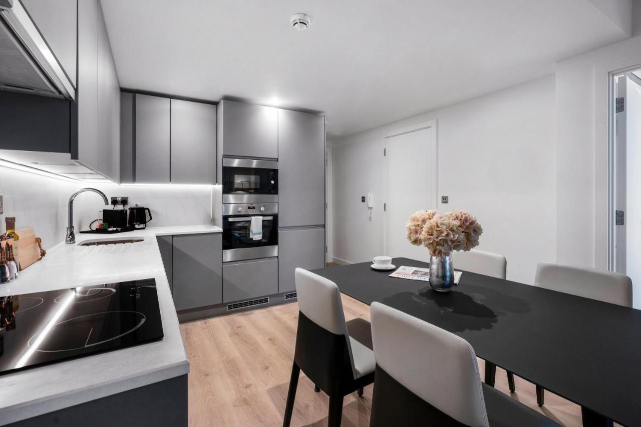 Citysuites 2 Aparthotel Manchester Exterior foto The photo shows a modern kitchen and dining area. The kitchen features sleek gray cabinets, a countertop with an embedded cooktop, and built-in appliances, including an oven and microwave. There’s a small coffee maker on the counter. Adjacent to the 