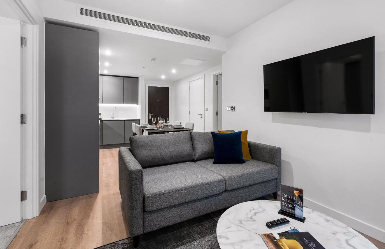 Citysuites 2 Aparthotel Manchester Exterior foto The photo shows a modern living space that includes a gray sofa with colorful cushions, a round marble coffee table, and a flat-screen TV mounted on the wall. In the background, there is a kitchen area featuring sleek cabinets. The flooring is light 