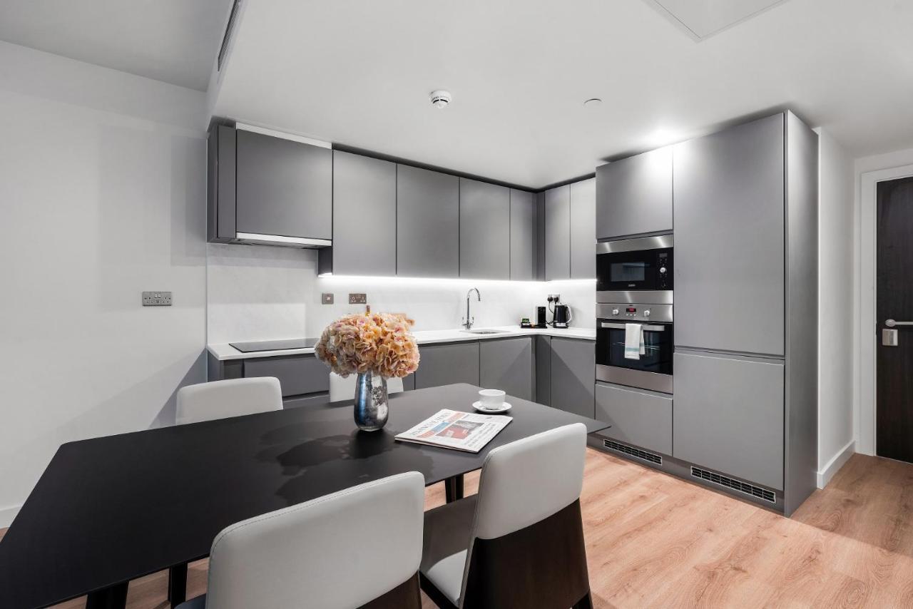 Citysuites 2 Aparthotel Manchester Exterior foto The photo shows a modern kitchen space. It features sleek, gray cabinetry with a minimalist design. There is a countertop with a sink, and appliances including an oven and a coffee maker. A dining table is positioned near the kitchen area, accompanie